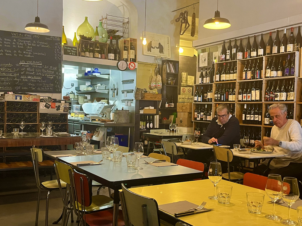 Wine bar La Part des Anges in Nice with bottles lining the walls and French aperitivo atmosphere
